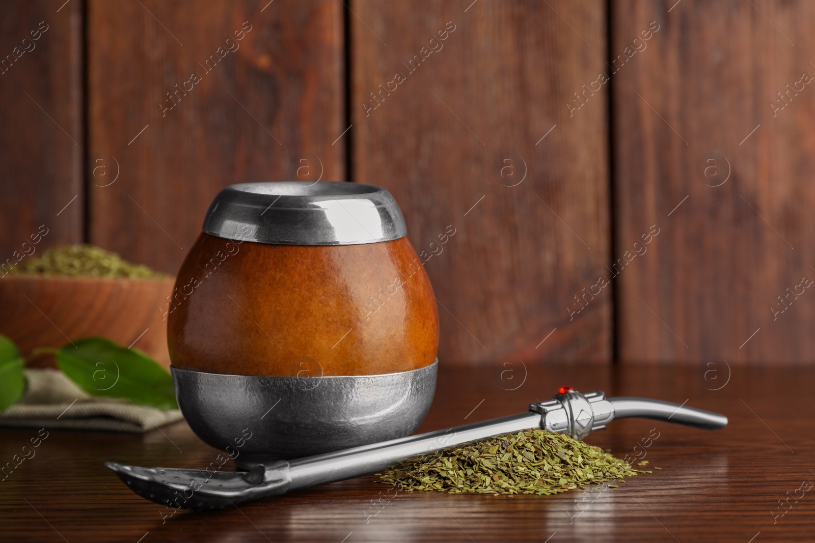 Photo of Calabash with mate tea and bombilla on wooden table