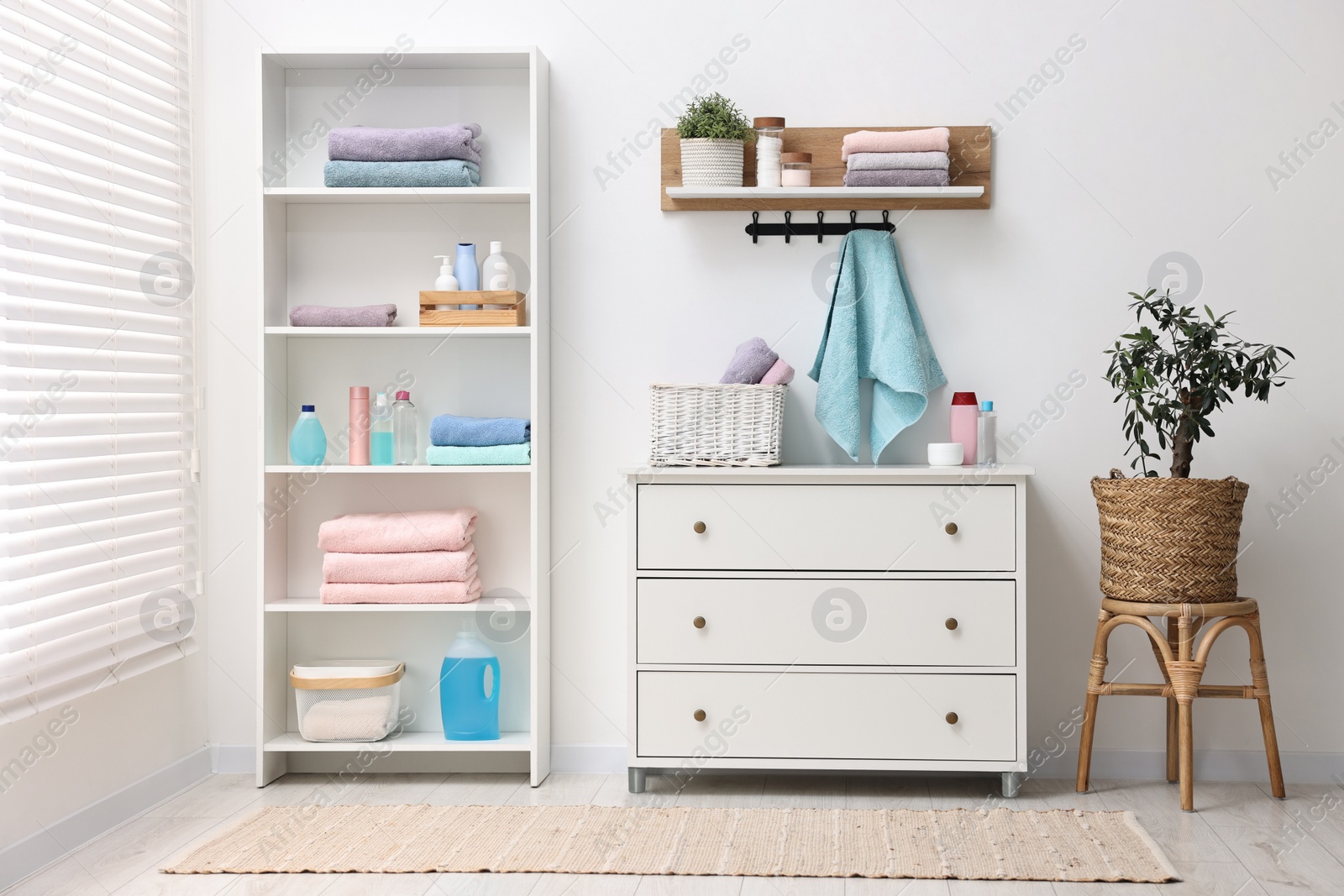 Photo of Shelving unit with stacked clean towels and toiletries in room