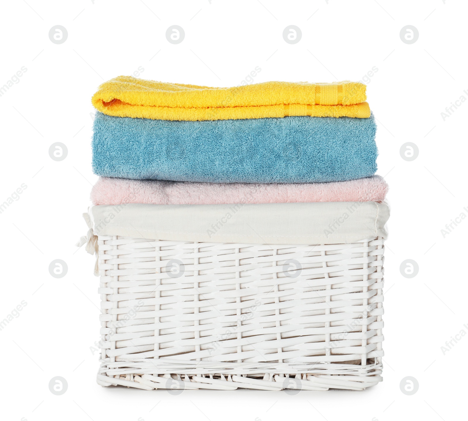 Photo of Folded towels in wicker basket on white background. Laundry day