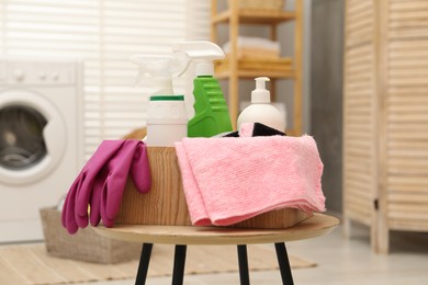 Different cleaning products in wooden box on table indoors