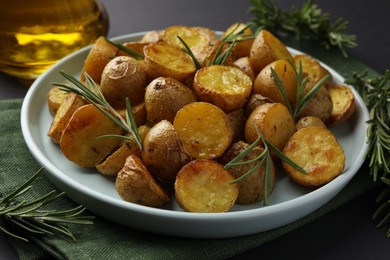 Photo of Delicious baked potatoes with rosemary on plate, closeup