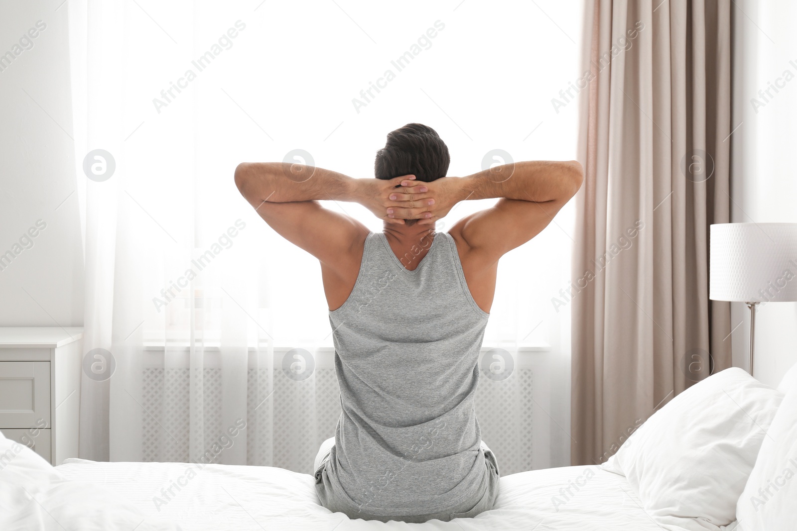 Photo of Man awakening on bed at home. Lazy morning