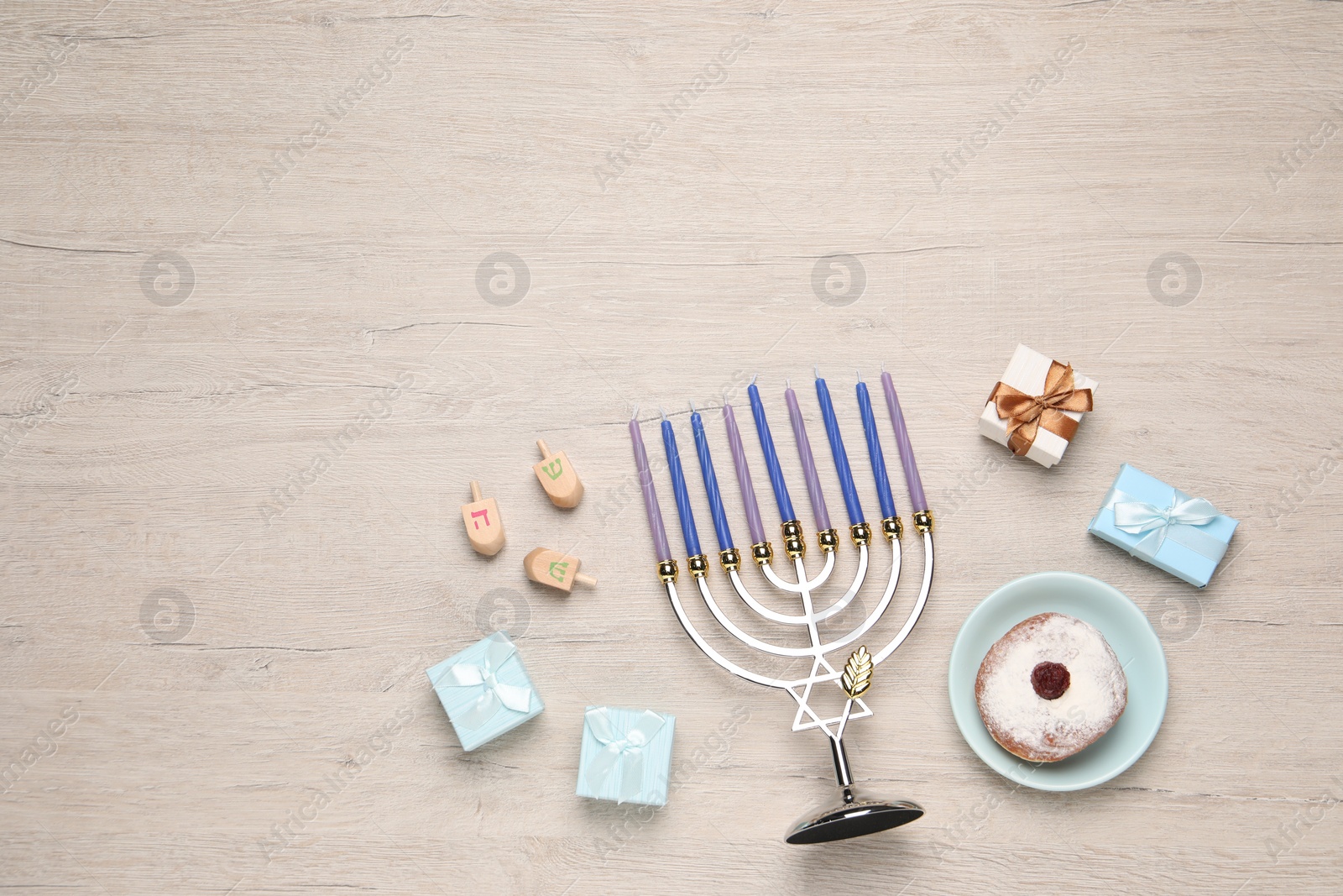 Photo of Flat lay composition with Hanukkah menorah and gift boxes on light wooden table. Space for text