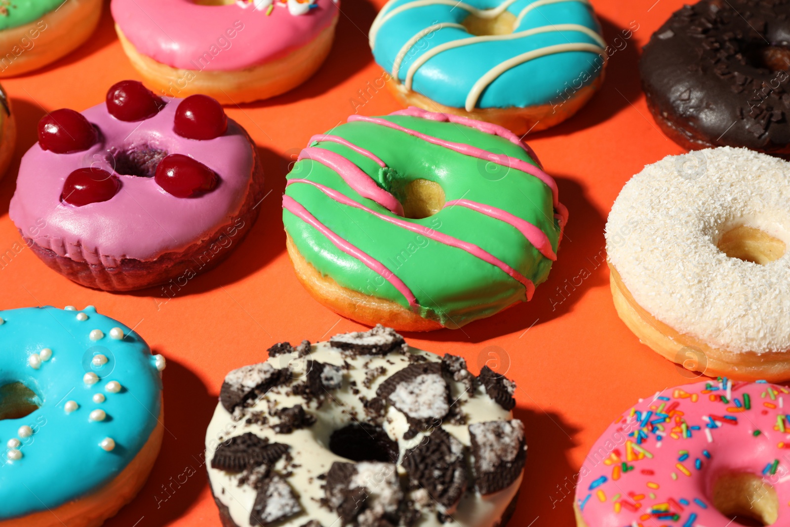 Photo of Sweet tasty glazed donuts on coral background