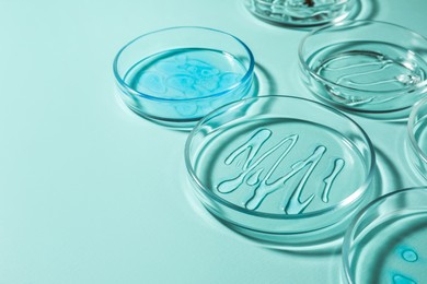 Petri dishes with liquids on turquoise background. Space for text