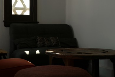 Photo of Cozy cafe interior with sofa, chairs and table
