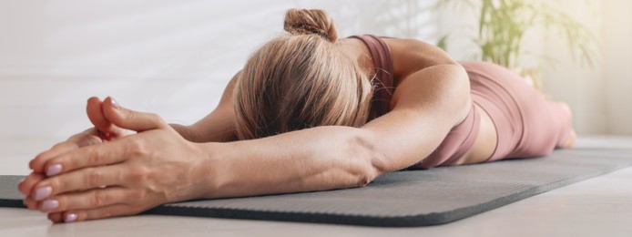 Image of Woman practicing yoga on floor at home. Horizontal banner design 