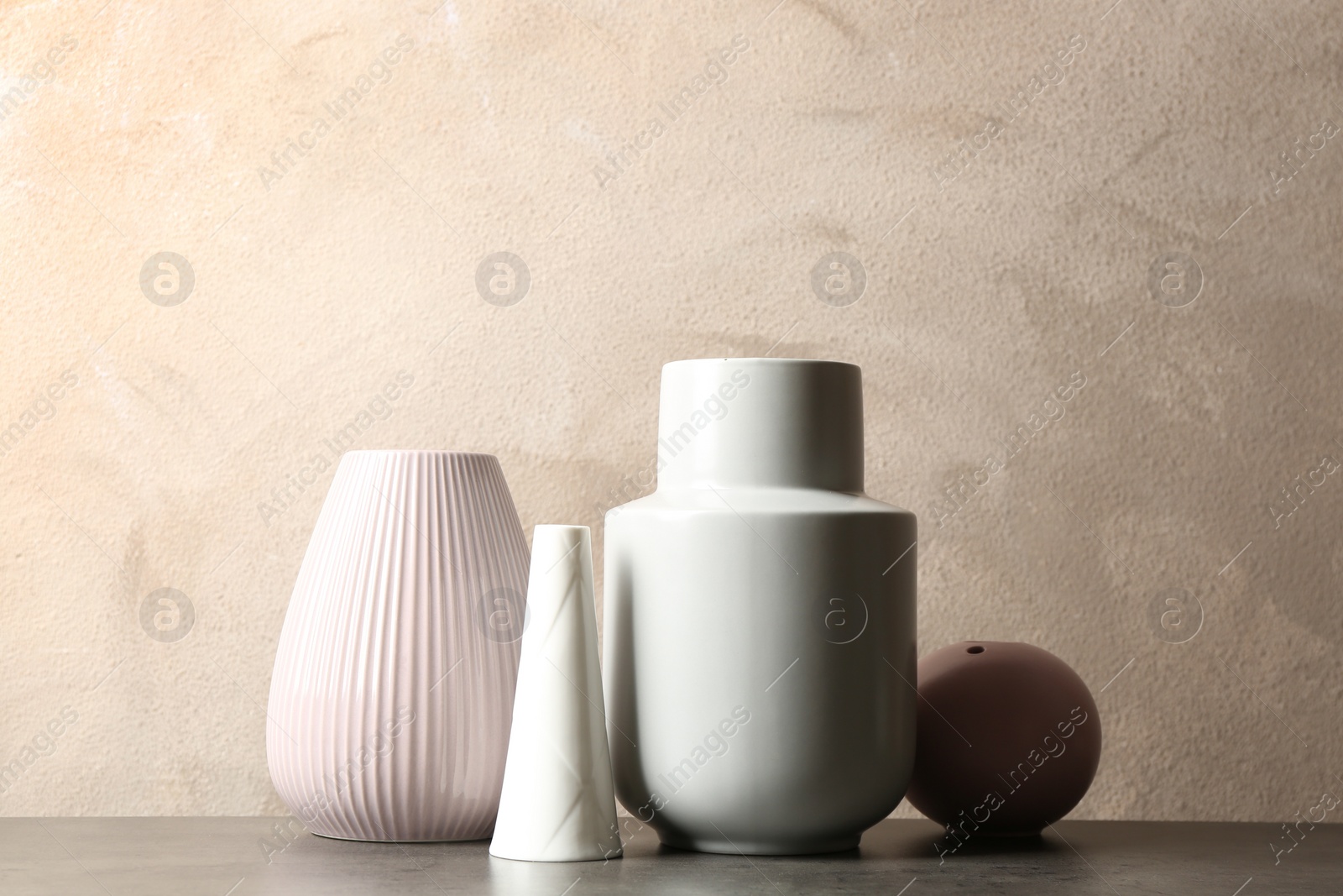 Photo of Stylish ceramic vases on grey stone table