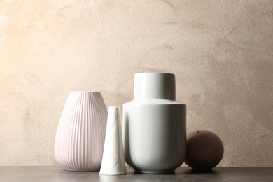 Stylish ceramic vases on grey stone table