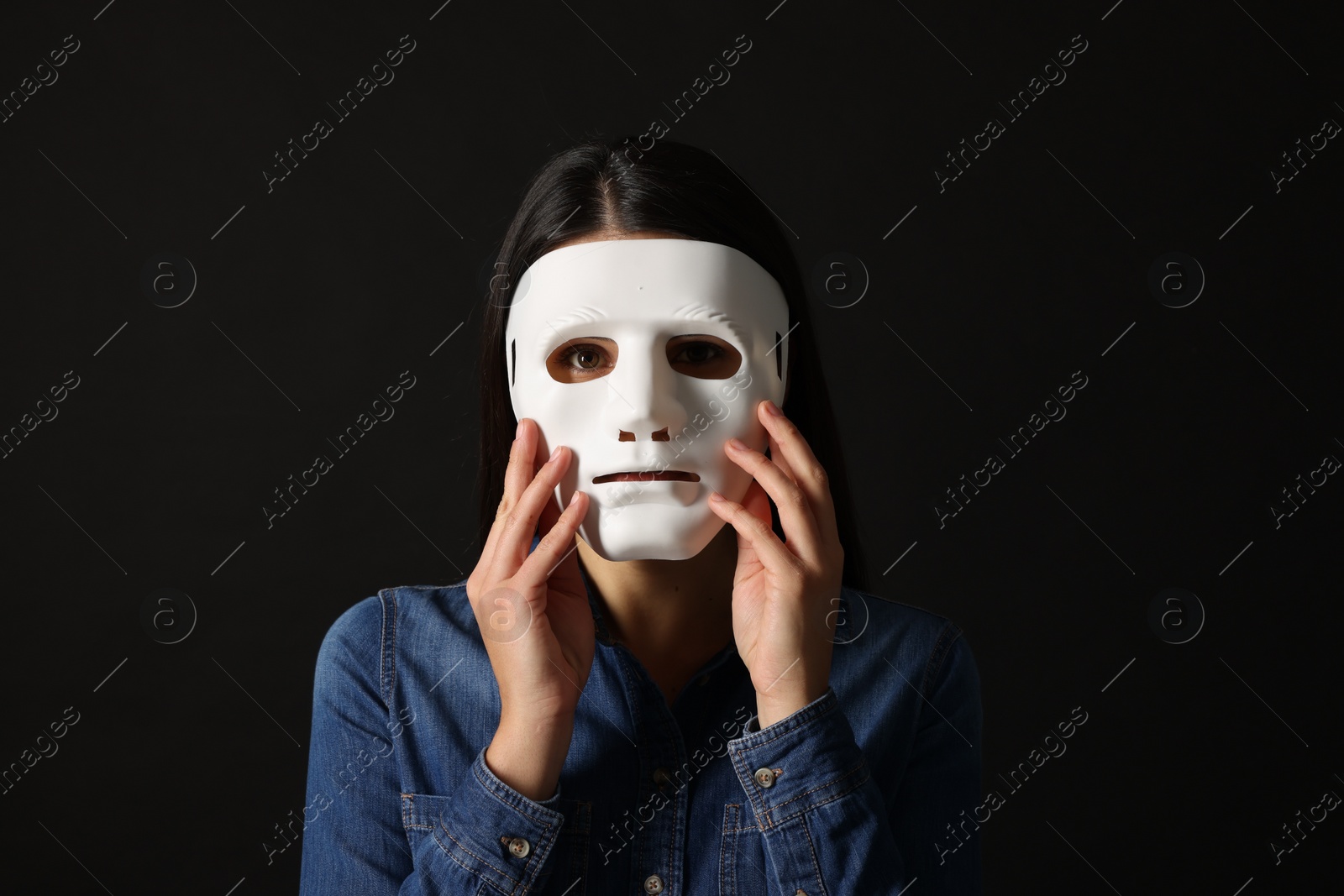 Photo of Multiple personality concept. Woman in mask on black background