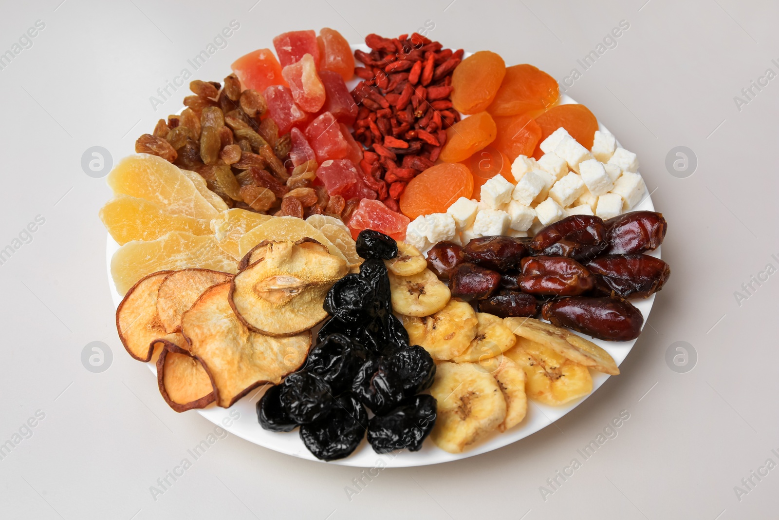 Photo of Plate with different dried fruits on white background