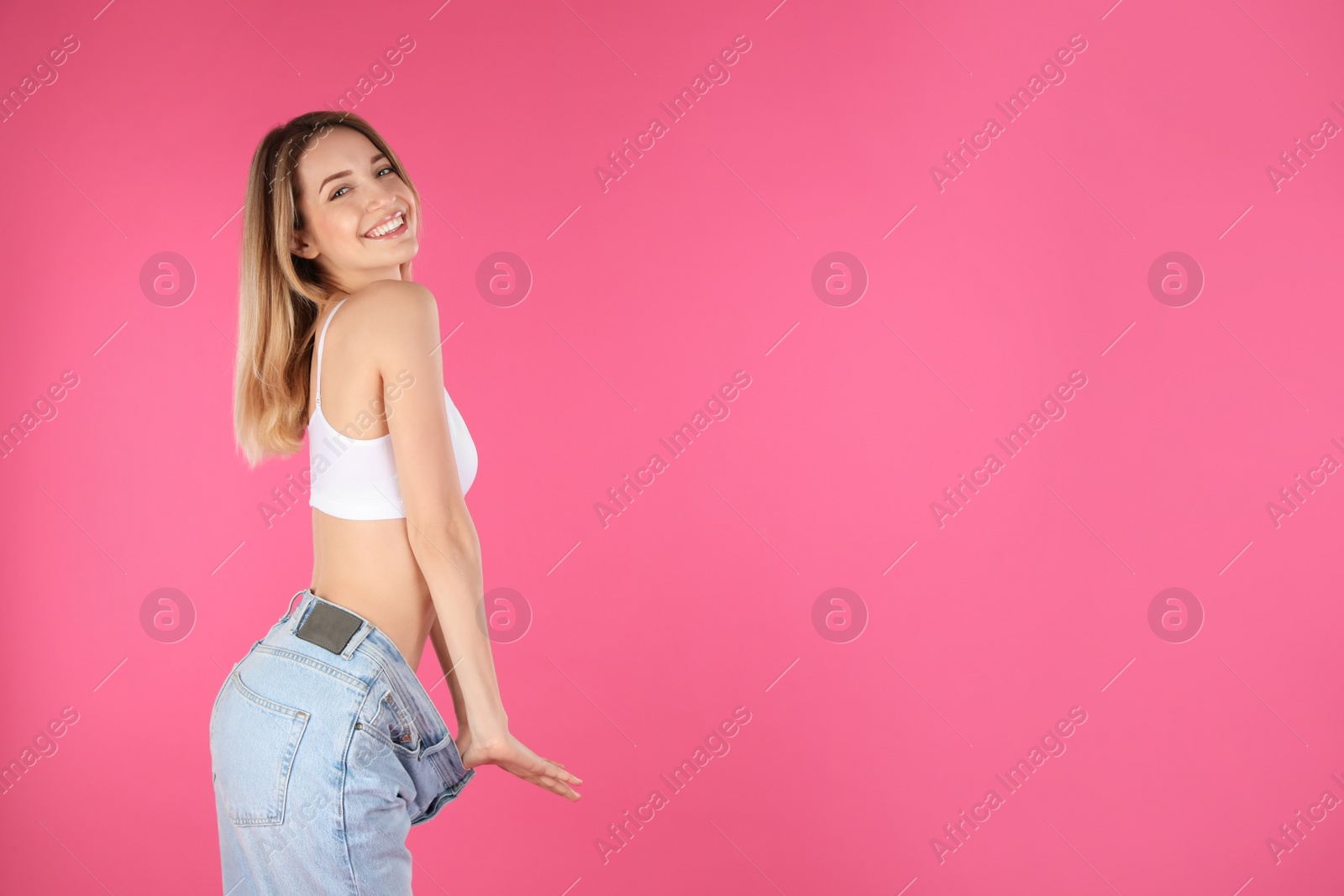 Photo of Slim woman in oversized jeans on color background, space for text. Perfect body