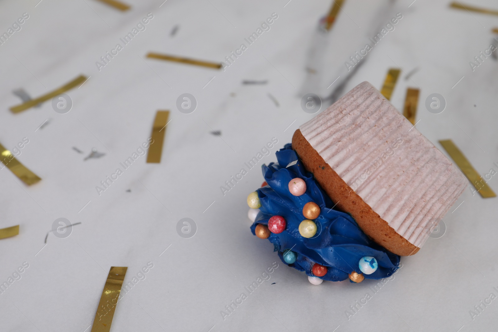 Photo of Cupcake dropped on white table, closeup. Troubles happen