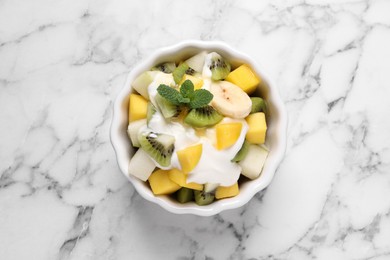 Photo of Delicious fruit salad on white marble table, top view