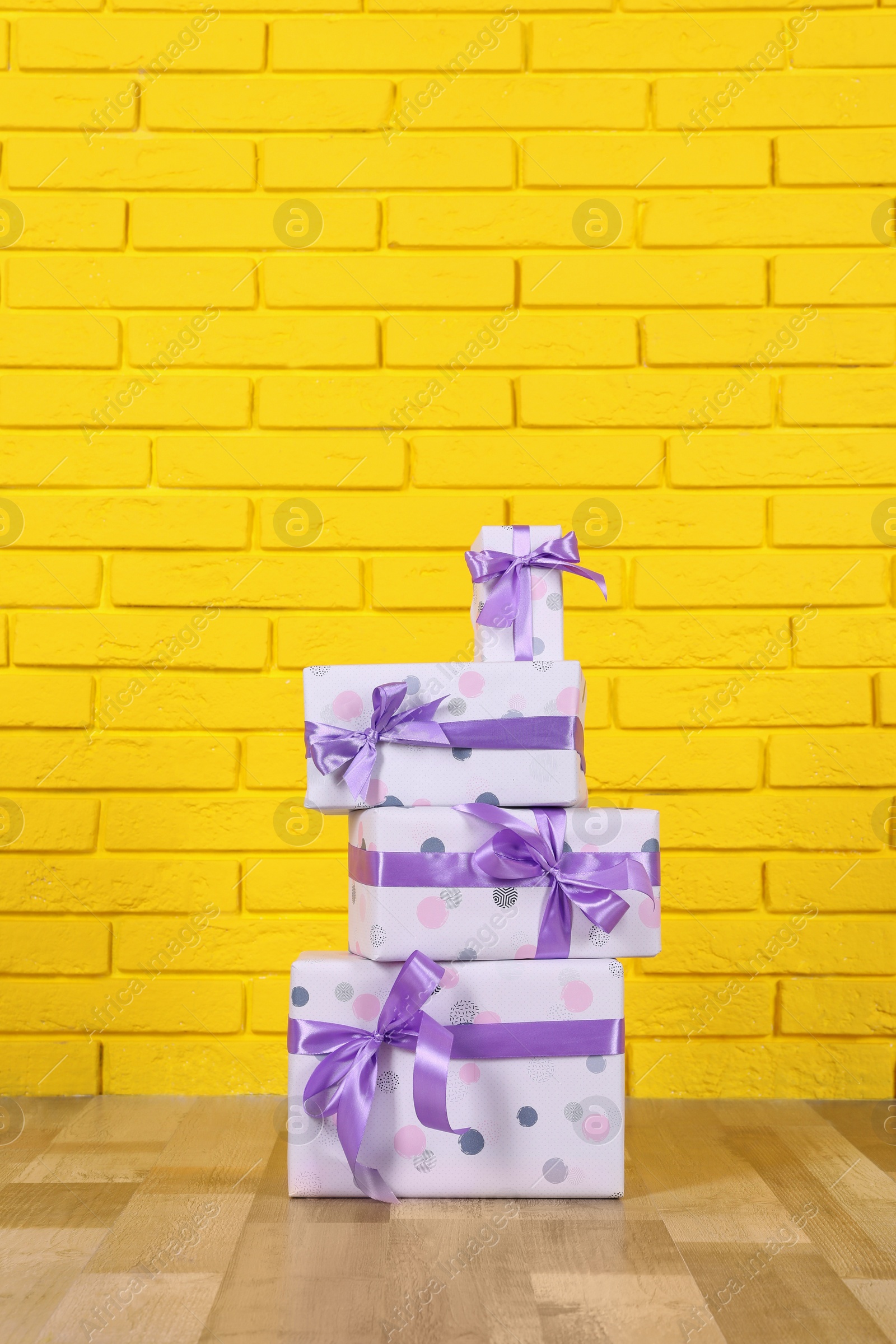 Photo of Gift boxes near yellow brick wall. Space for text