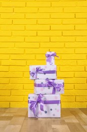 Photo of Gift boxes near yellow brick wall. Space for text
