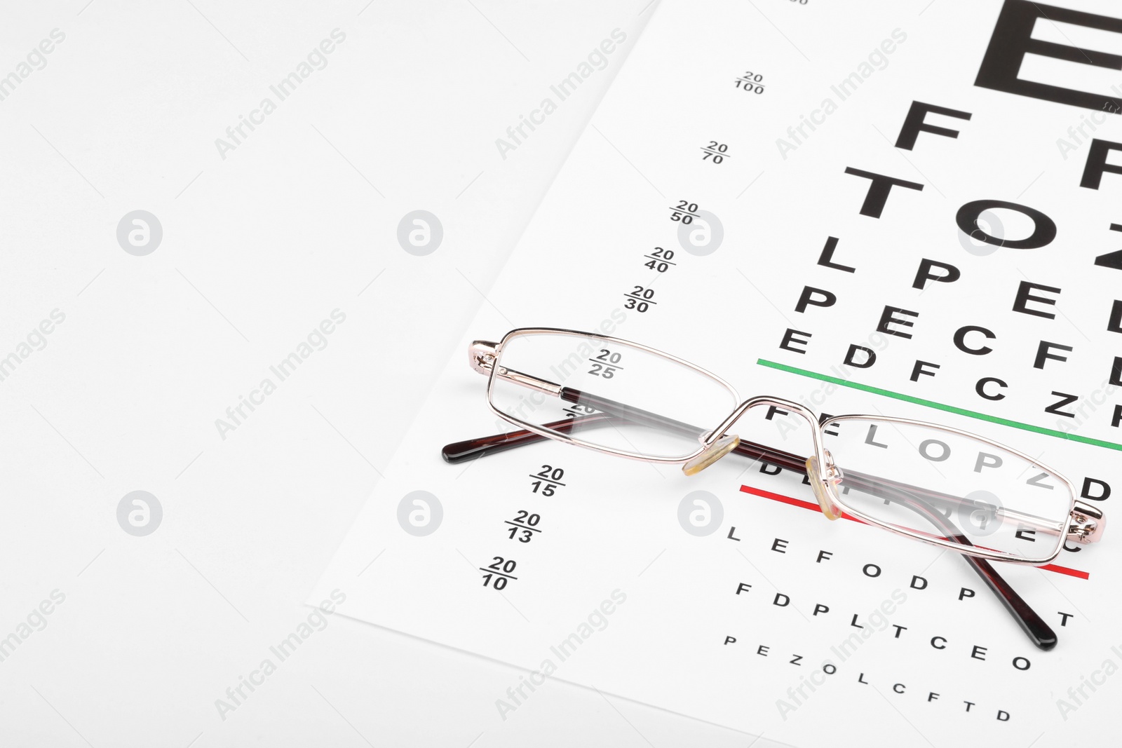 Photo of Glasses and vision test chart isolated on white