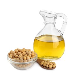 Glass jug of oil and soybeans on white background