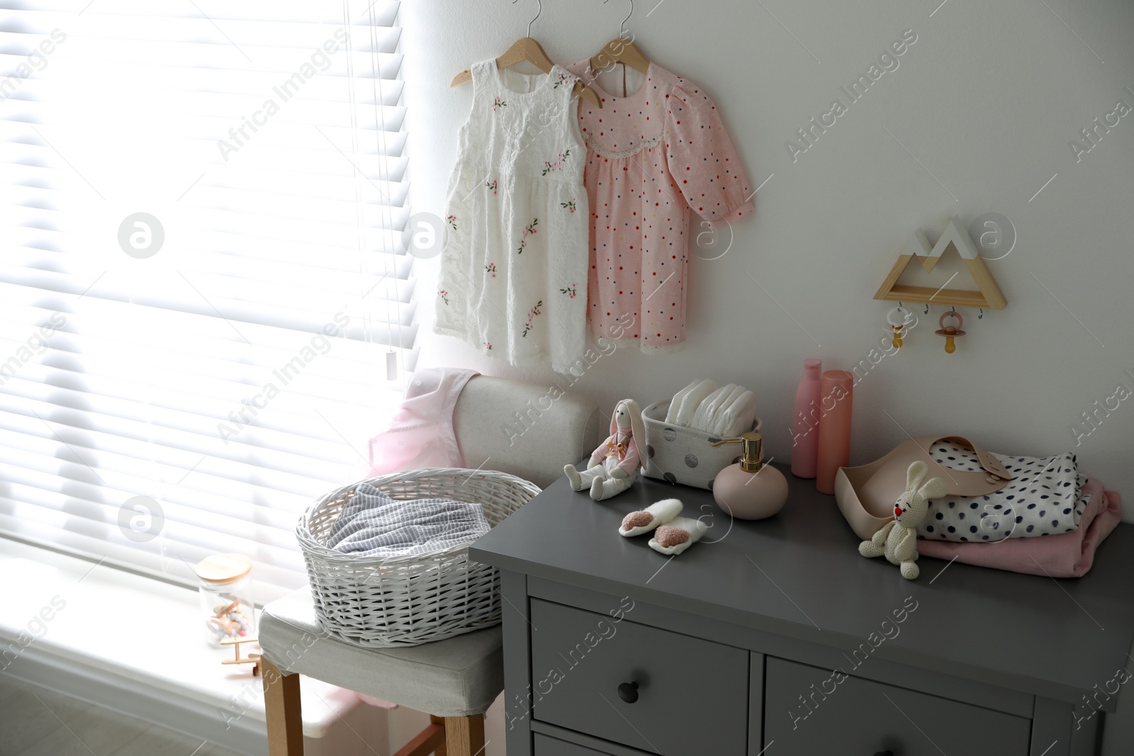 Photo of Stylish chest of drawers and accessories in child room