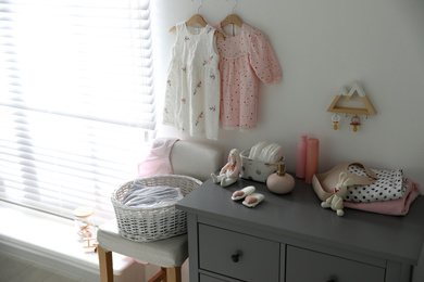 Photo of Stylish chest of drawers and accessories in child room