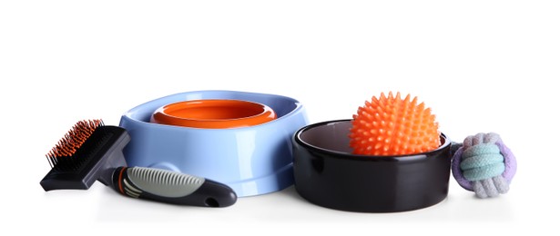 Photo of Feeding bowls, brush and dog toys on white background
