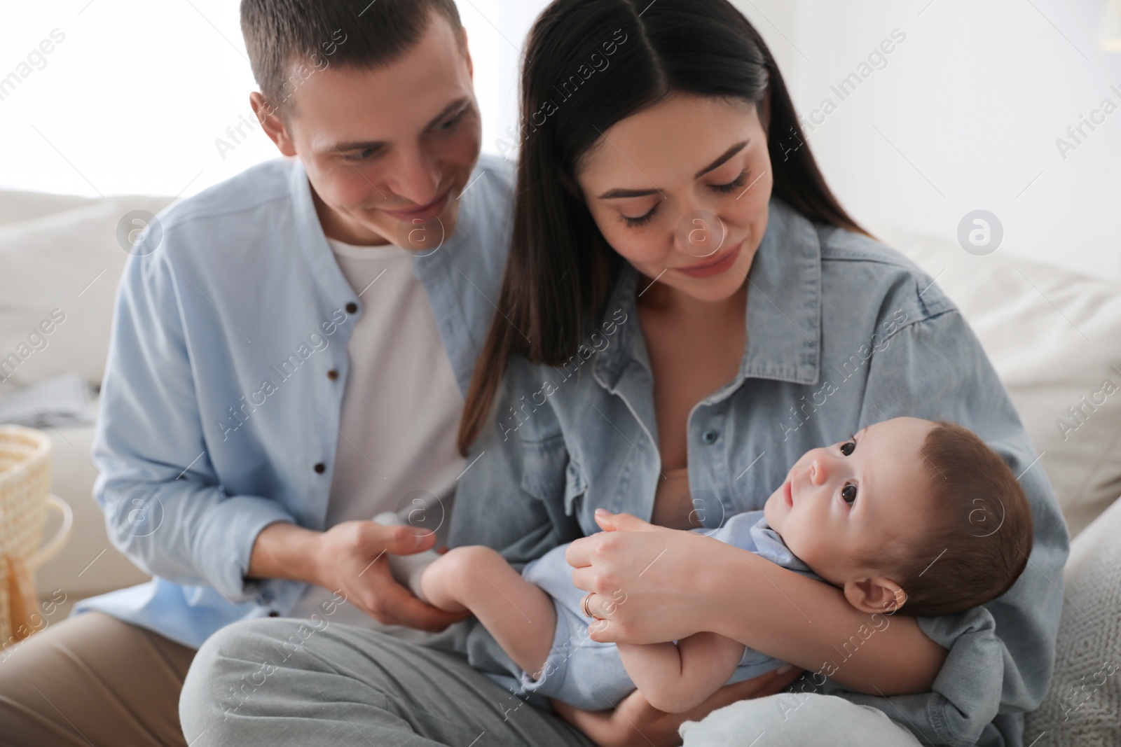 Photo of Happy family with cute baby on sofa at home