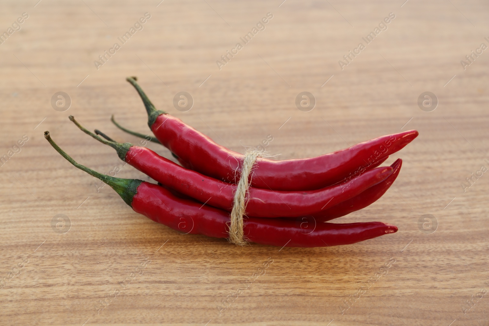 Photo of Red ripe chili peppers on wooden table