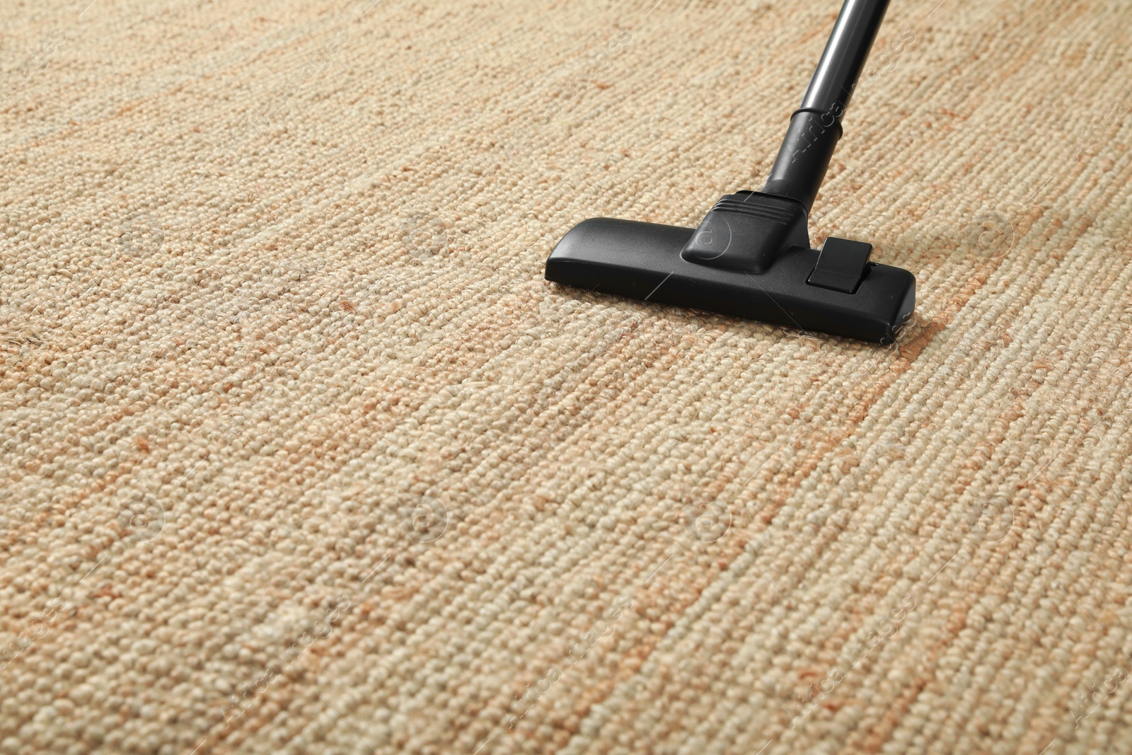 Photo of Removing dirt from beige carpet with modern vacuum cleaner. Space for text