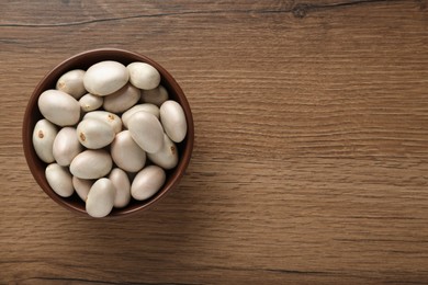 Photo of Raw jackfruit seeds on wooden table, top view. Space for text