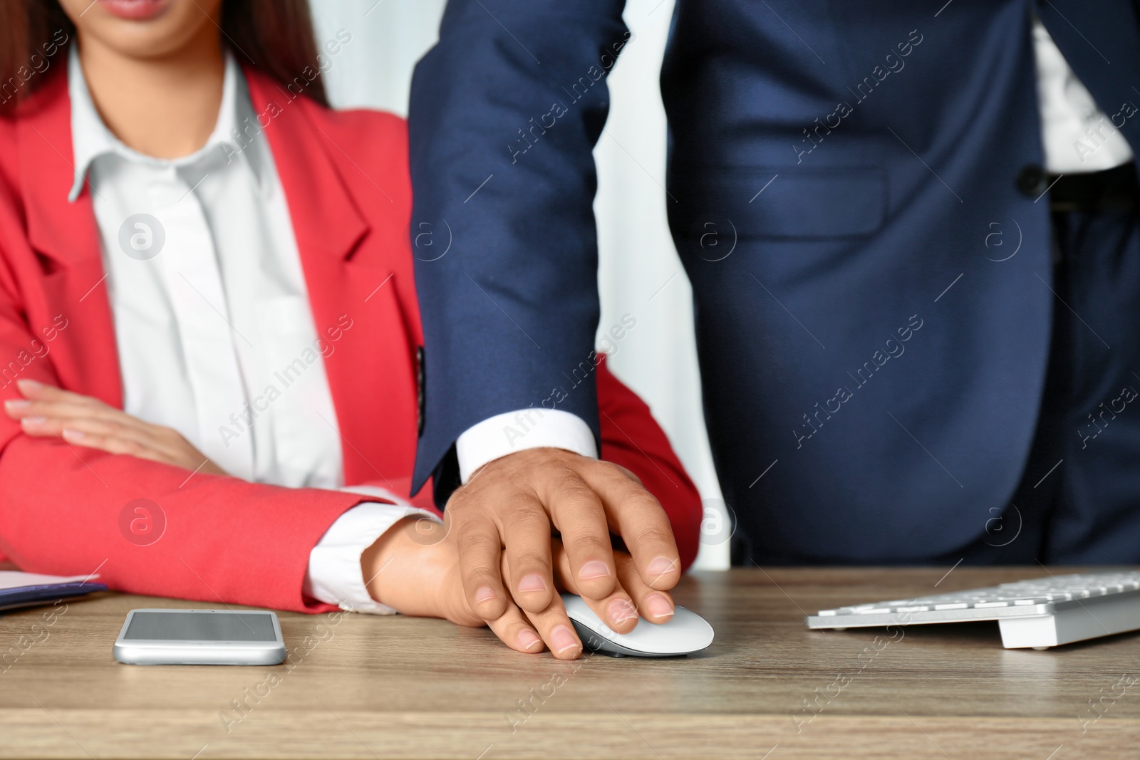 Photo of Boss molesting his female secretary in office, closeup. Sexual harassment at work