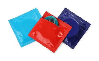 Photo of Packaged condoms on white background, top view. Safe sex
