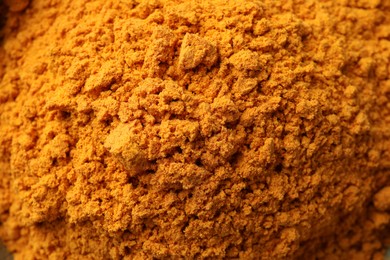 Photo of Aromatic turmeric powder as background, closeup view