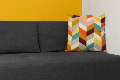 Photo of Bright cushion on grey sofa in room