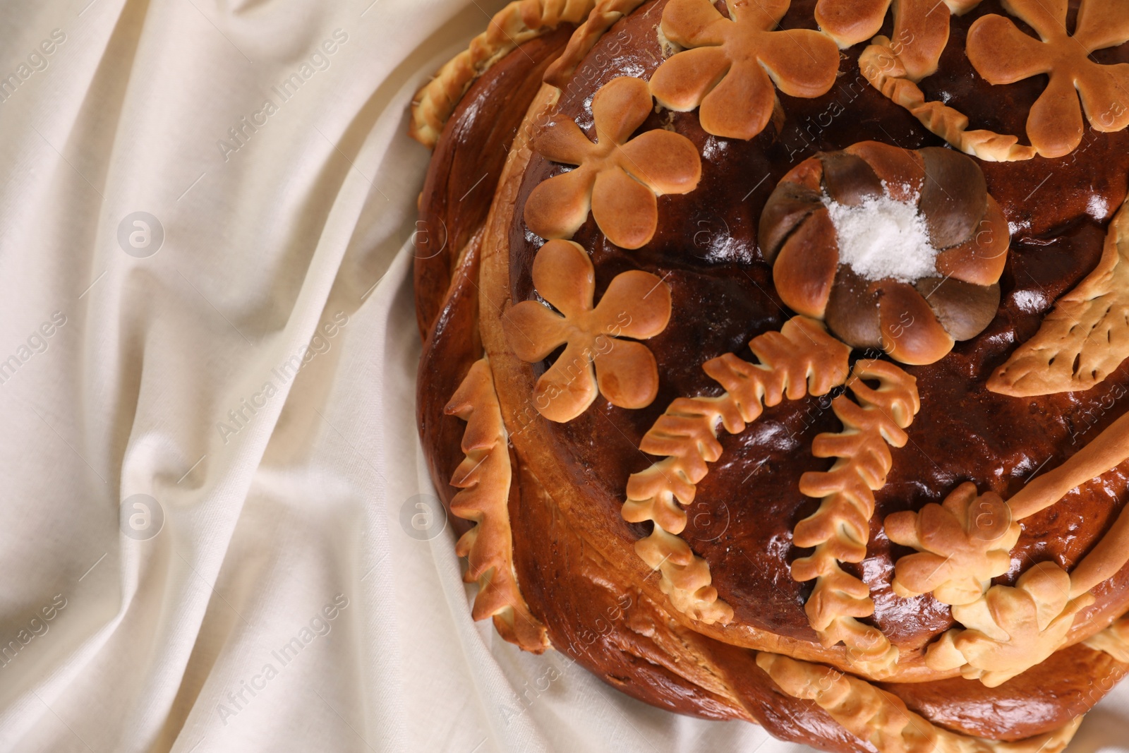 Photo of Korovai on tablecloth, top view. Ukrainian bread and salt welcoming tradition