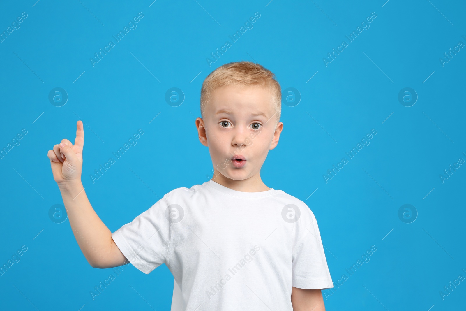 Photo of Portrait of cute little boy on light blue background