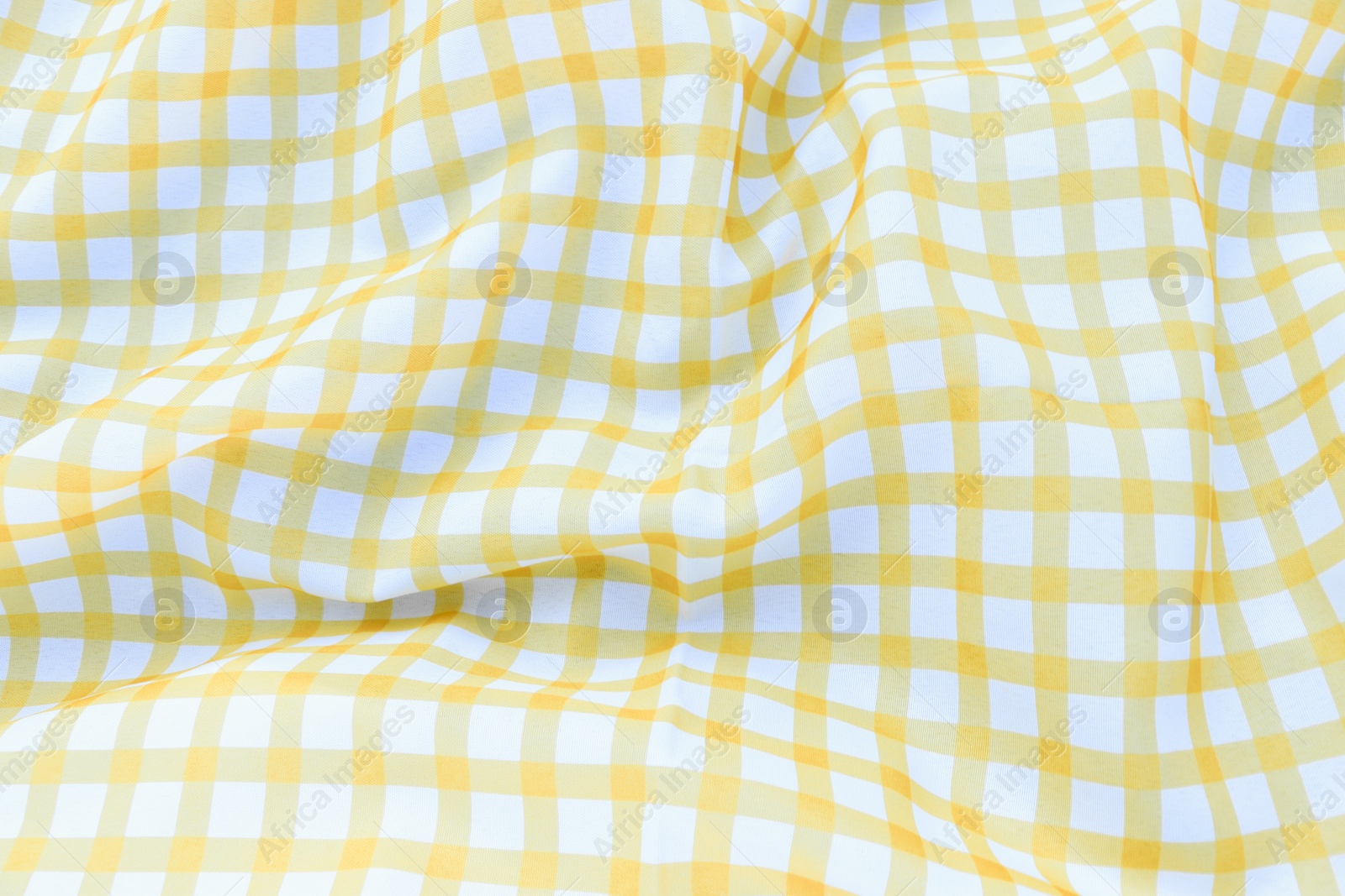 Photo of Yellow checkered picnic tablecloth as background, closeup