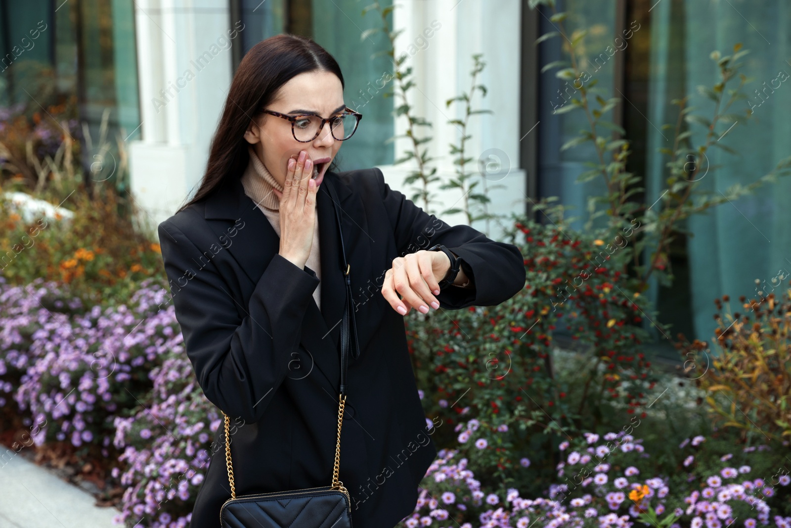 Photo of Emotional woman checking time on watch outdoors. Being late concept