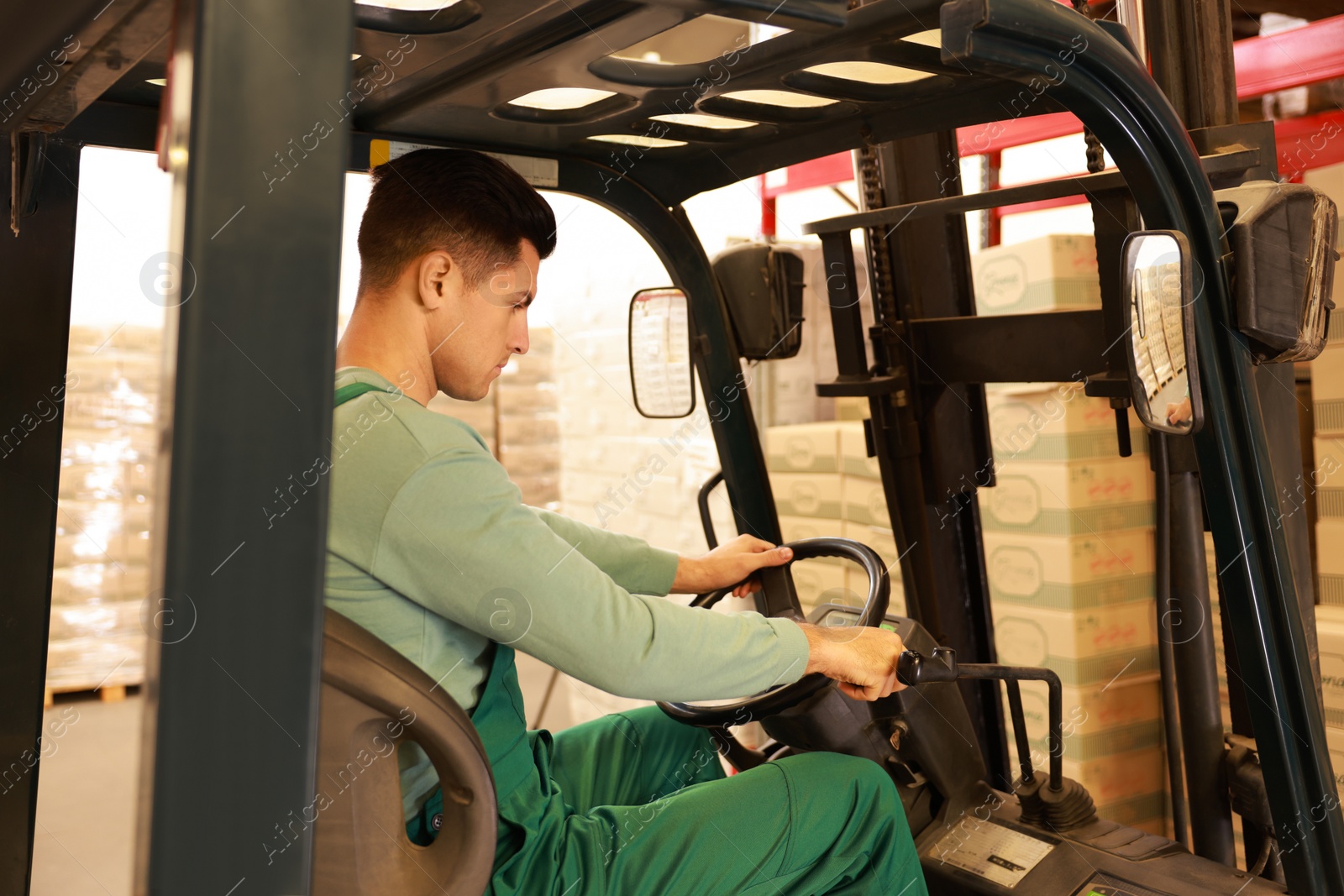 Image of Worker sorting cardboard boxes with forklift truck in warehouse. Logistics concept