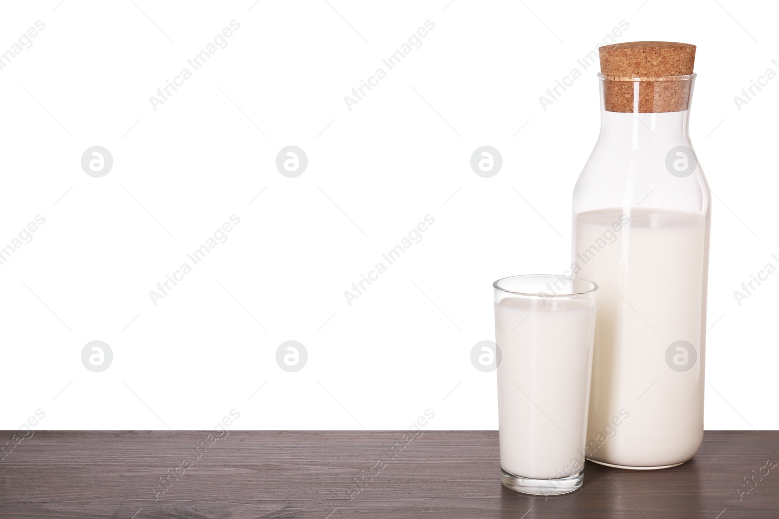 Photo of Glassware with tasty milk on wooden table against white background