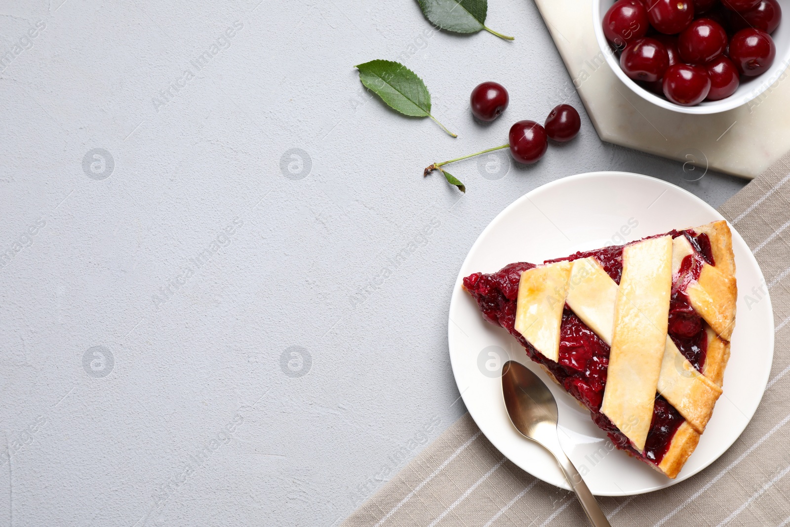 Photo of Delicious fresh cherry pie served on light grey table, flat lay. Space for text