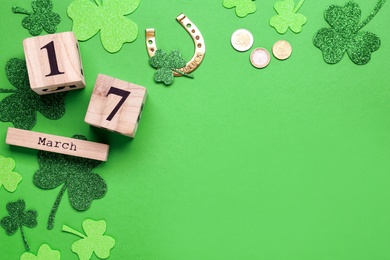 Flat lay composition with block calendar on green background, space for text. Saint Patrick's Day celebration