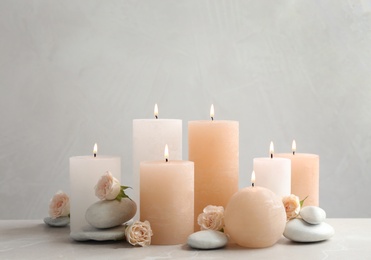 Beautiful composition with candles on table against grey background