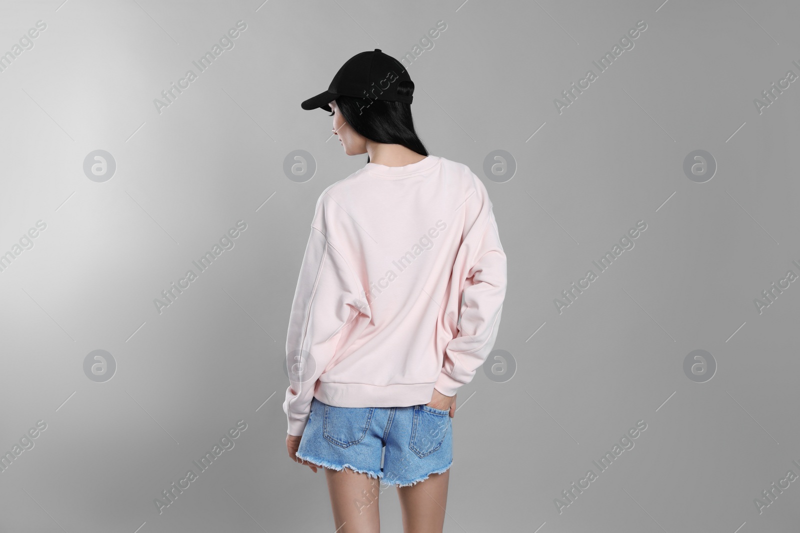 Photo of Young woman in sweater on grey background. Mock up for design