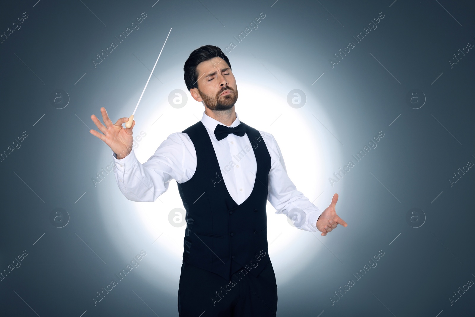 Photo of Professional conductor with baton on grey background