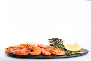 Photo of Delicious cooked shrimps served with lemon, pepper and rosemary on white background