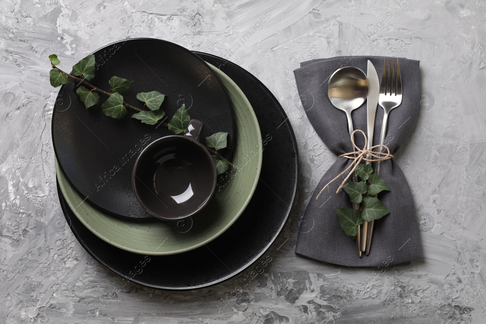 Photo of Stylish table setting. Dishes, cutlery, napkin and floral decor, top view
