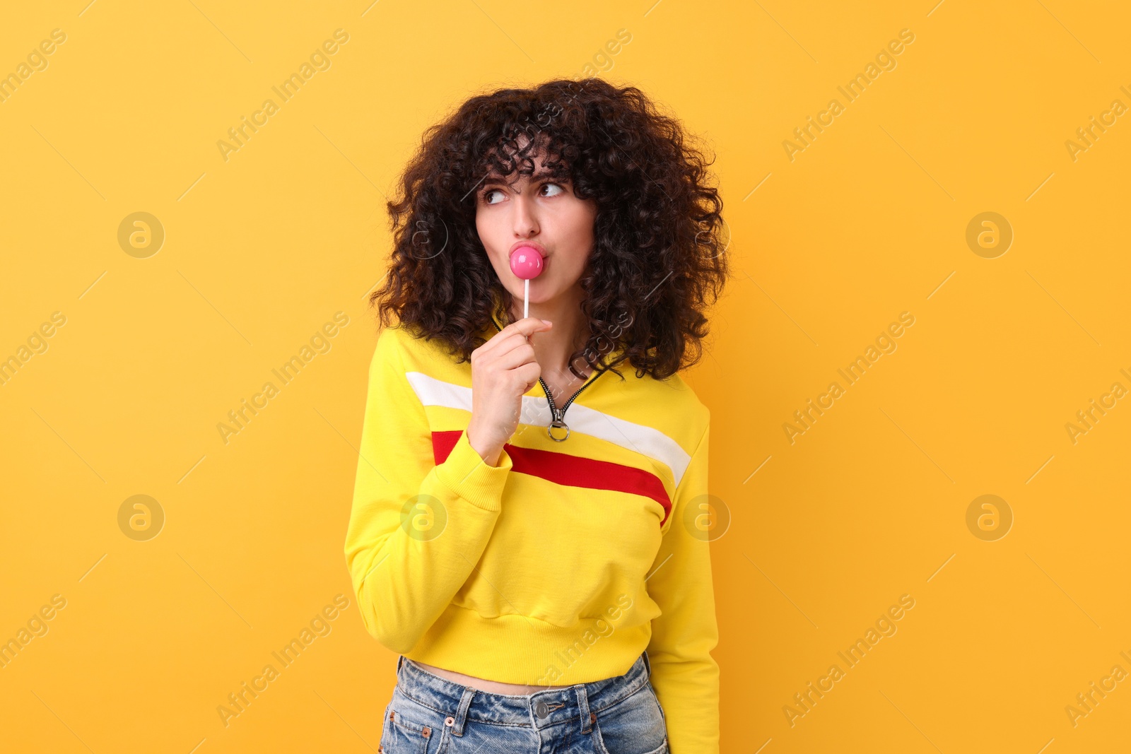 Photo of Beautiful woman with lollipop on yellow background