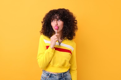 Photo of Beautiful woman with lollipop on yellow background