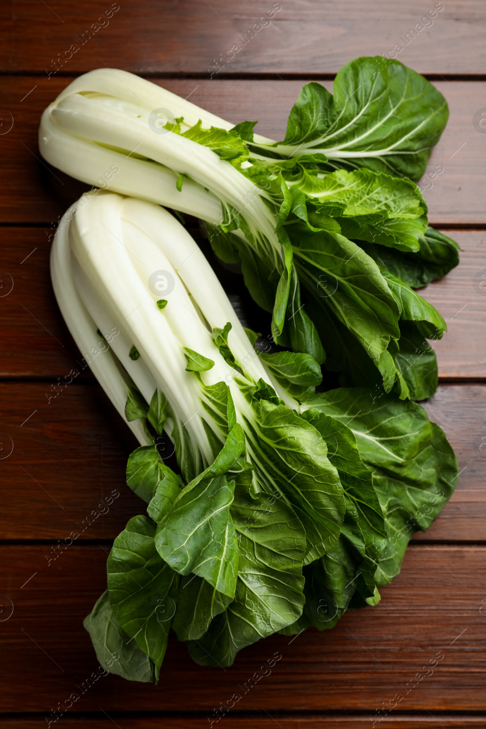 Photo of Fresh green pak choy cabbages on wooden table, flat lay