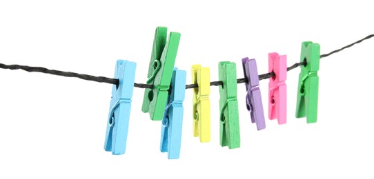 Photo of Many colorful wooden clothespins on rope against white background